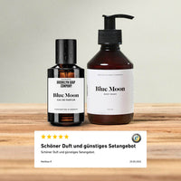Brooklyn Soap Company Blue Moon Eau de Parfum und Body Wash auf einem Holztisch mit Kundenbewertung, die Duft und günstiges Setangebot lobt.