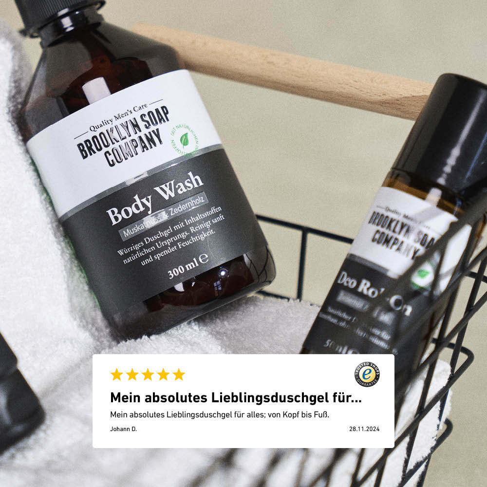 Body Wash und Deo Roll-On im Metallkorb mit Handtuch, darunter eine Kundenbewertung zum Lieblingsduschgel.