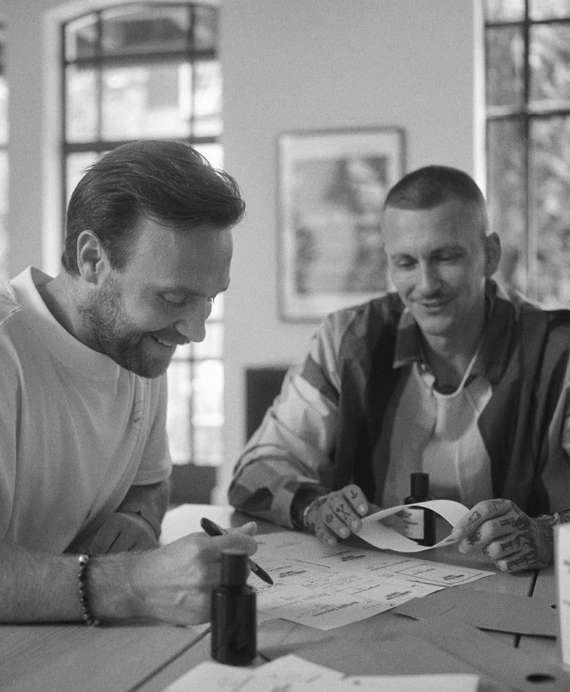 Zwei Männer – der CEO von Brooklyn Soap und Willy – sitzen gemeinsam an einem Tisch und besprechen Produktdesigns.