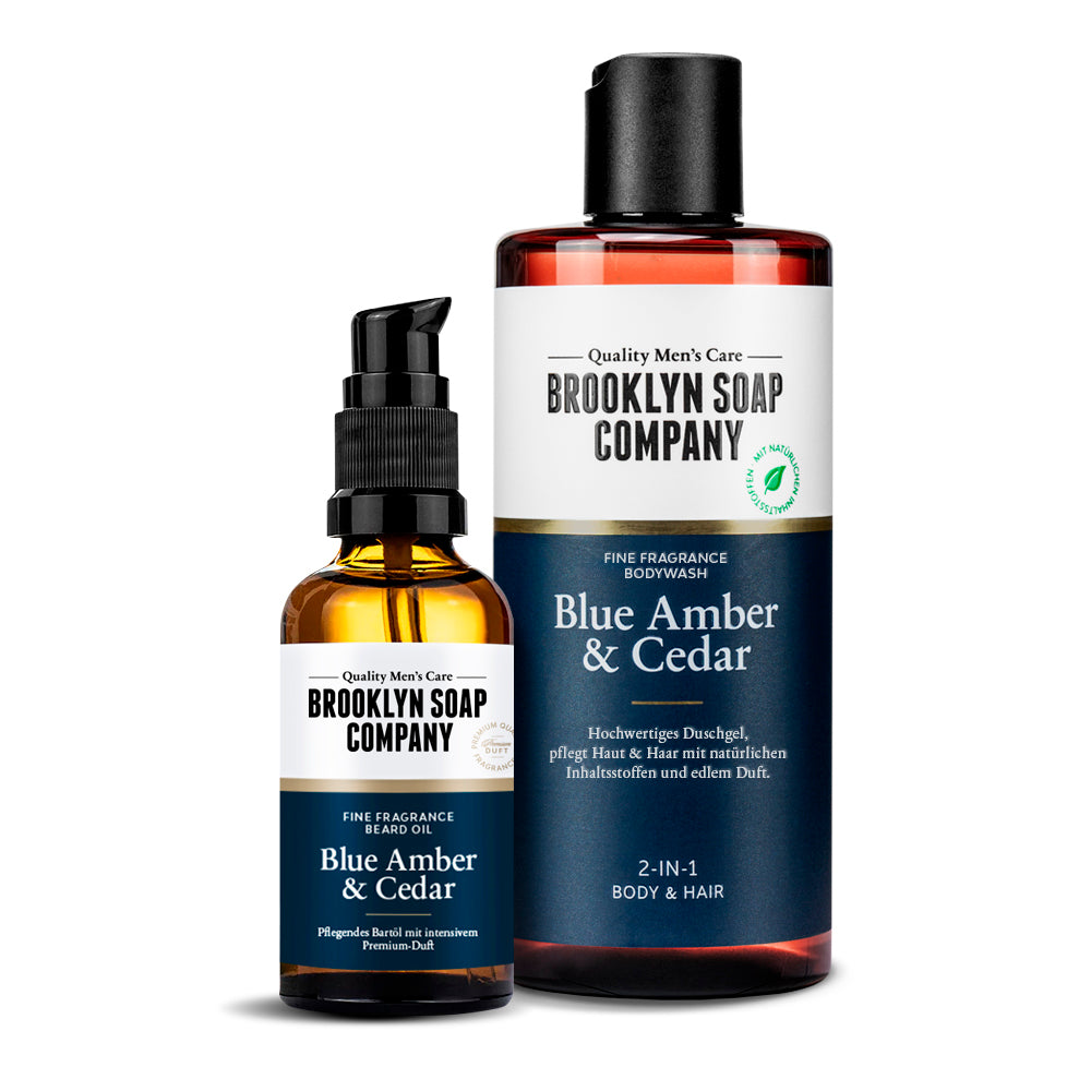 Brooklyn Soap Bartöl und Duschgel Blue Amber & Cedar – braune Glasflasche mit Pumpspender und passende Duschgel-Flasche im Set, vor weißem Hintergrund.